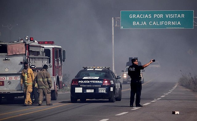 DAÑOS. Cuerpo de Bomberos laboran el la zona del incendio este viernes, en la ciudad de Tijuana, en el estado de Baja California (México)