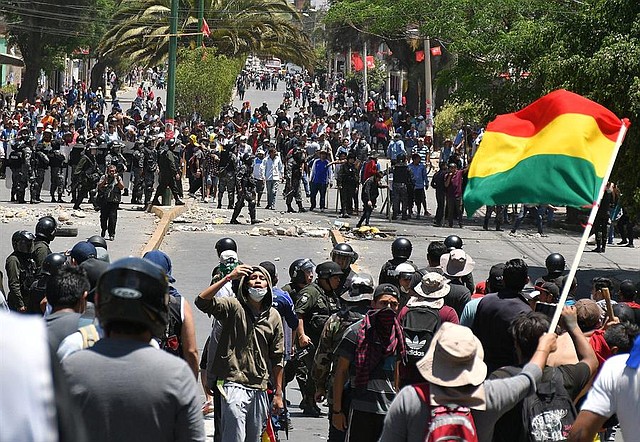 CRISIS. Manifestantes se enfrentan con policías antidisturbios este lunes en Cochabamba