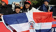 ALEGRES. La salvadoreña Mirna Ochoa (izq.) y la dominicana Giselle Rodríguez con la bandera de la República Dominicana / José Luis Argueta