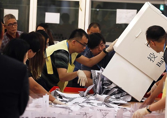 ELECCIONES. Funcionarios cuentan las boletas en una mesa electoral cuando se cierra oficialmente la votación en Hong Kong, China, el 24 de noviembre de 2019