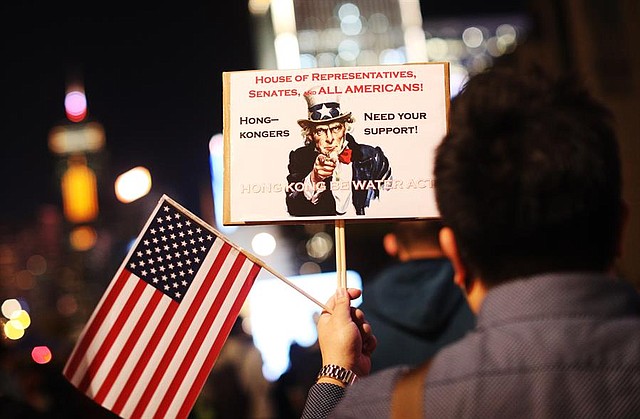 MUNDO. Un manifestante a favor de la democracia sostiene una pancarta y una bandera nacional de Estados Unidos durante una manifestación del Día de Acción de Gracias en Edimburgo Place, Hong Kong, China, el 28 de noviembre de 2019