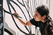 ARTE. La artista Vero Rivera trabajando en su mural