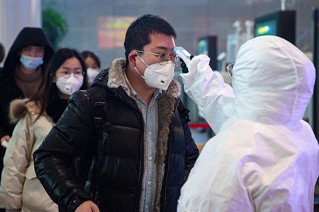 SALUD. Personal médico verifica la temperatura de los pasajeros en la estación de ferrocarril del sur de Nanjing, en la provincia de Jiangsu, China, el 27 de enero. | Foto: Efe.