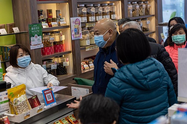 SALUD. Personas hacen fila para comprar nuevas máscaras faciales en una farmacia de Hong Kong, China para protegerse del coronavirus