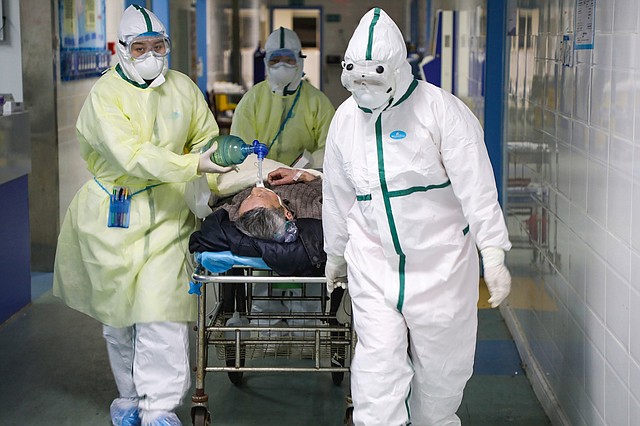 SALUD. Personal médico traslada a un paciente con coronavirus a la sala de aislamiento de un hospital en Wuhan, provincia de Hubei, China, el 6 de febrero de 2020. | Foto: Efe.