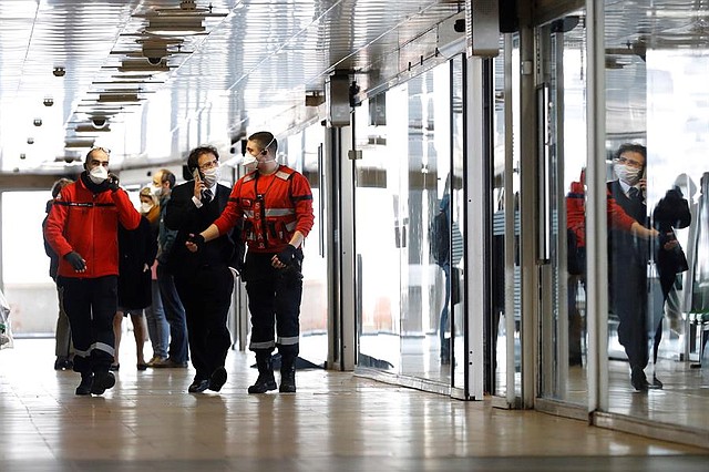 ACCIONES. Autoridades con máscaras faciales caminan junto a un autobús de la ciudad italiana de Milán que ha sido puesto en cuarentena tras la detección de un presunto caso de la enfermedad COVID-19 en Lyon, Francia, el 24 de febrero de 2020