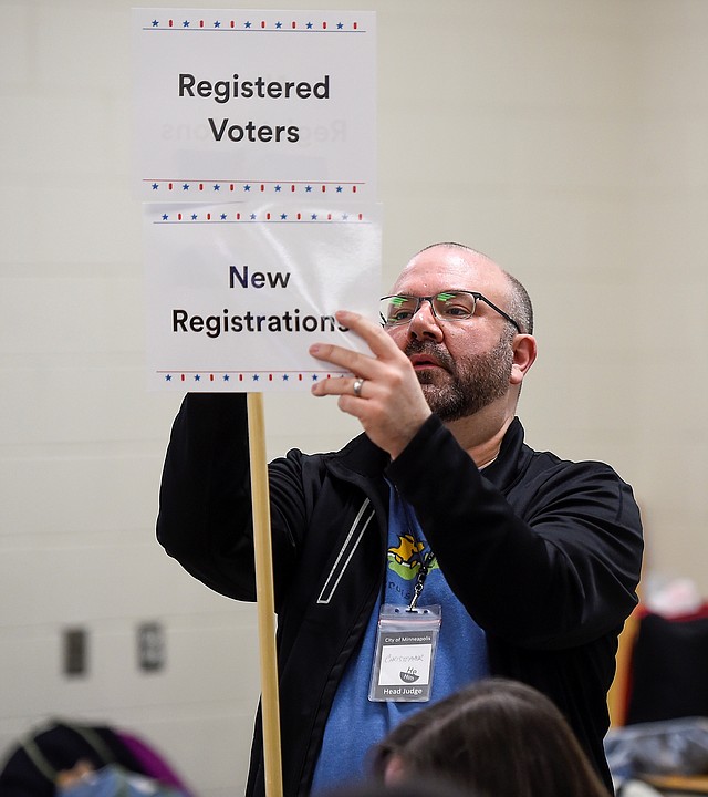 POLÍTICA. El juez principal de elecciones, Christopher Foster, coloca un letrero cuando los electores ingresan en un centro de votación en Minneapolis, Minnesota, el 3 de marzo de 2020. | Foto: Efe/ CRAIG LASSIG.