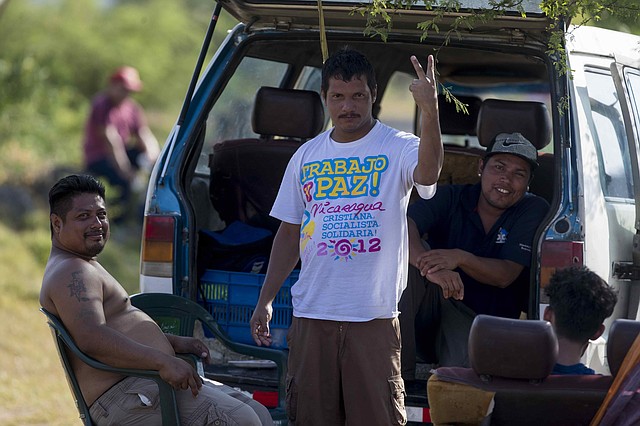 FESTEJO. Un hombre con una camisa de propaganda política del gobierno (c), junto con varios amigos y sin ninguna medida de prevención ante el coronavirus, en las afueras de Managua. Foto: Efe/Jorge Torres.