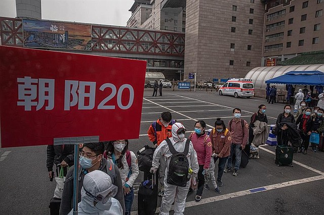CHINA. Los pasajeros que llegan de Wuhan esperan sus autobuses dedicados, en la estación de tren de Beijing, China, el 15 de abril de 2020