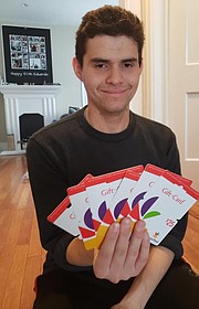 Esteban mostrando algunas de las tarjetas de regalos que serán donadas.