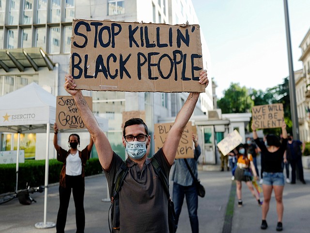 PROTESTA. Un manifestante sostiene un letrero en el que se lee “Deja de matar a personas negras”, durante una manifestación frente al consulado de Estados Unidos, En Milán, Italia, el 28 de mayo de 2020. | Foto: Efe/Andrea Fasani.