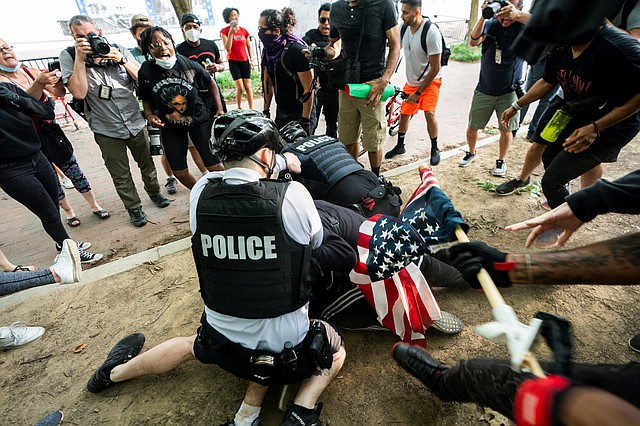 MANIFESTACIÓN. Oficiales de policía abordan a un manifestante cerca de la Casa Blanca, durante una protesta por la muerte de George Floyd, el 29 de mayo de 2020. | Foto: Efe/Jim Lo Scalzo.