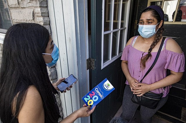 La directora del Centro Presente, Patricia Montes, le explica a Angélica la importancia de completar el censo de 2020 mientras entrega alimentos a las familias necesitadas en East Boston.
