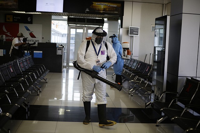 REAPERTURA. Trabajadores desinfectan salas de espera en el aeropuerto internacional "Oscar Arnulfo Romero" en San Salvador, el 17 de agosto. | Foto: eFE/ Rodrigo Sura.