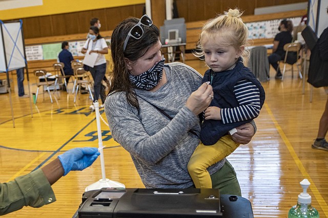 FAMILIA. Milo Grady, de dos años de edad, recibe una calcomanía de su madre después de que ella emitió su voto para votar en el Distrito 1 de la Escuela Secundaria de East Boston
