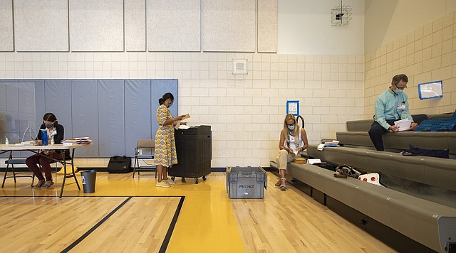 ELECCIONES. Los trabajadores electorales de la Escuela Ruffin Ridley de Florida en Brookline clasifican e introducen las boletas de votación anticipada del precinto 3 en una máquina de votación
