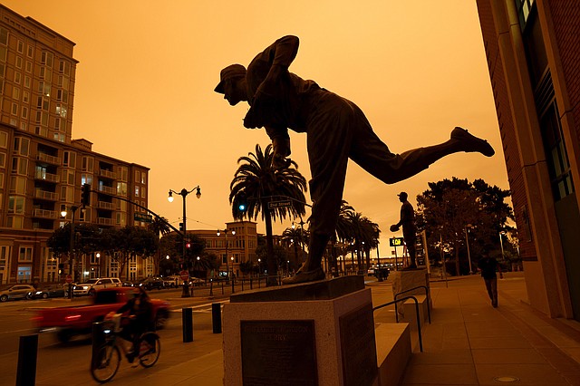 TIEMPO. La estatura homenaje al histórico jugador de los Giants de San Francisco, Gaylord Perry, se observó bajo el cielo anaranjado en la ciudad de San Francisco el miércoles 9 de septiembre, debido a los incendios forestales activos. | Foto: Efe/Etienne Laurent.