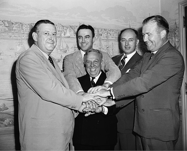 Leo Ferris (segundo de izquierda a derecha) y representantes de la NBL y BAA se dan la mano después de acordar la fusión que crearía la NBA en 1949.