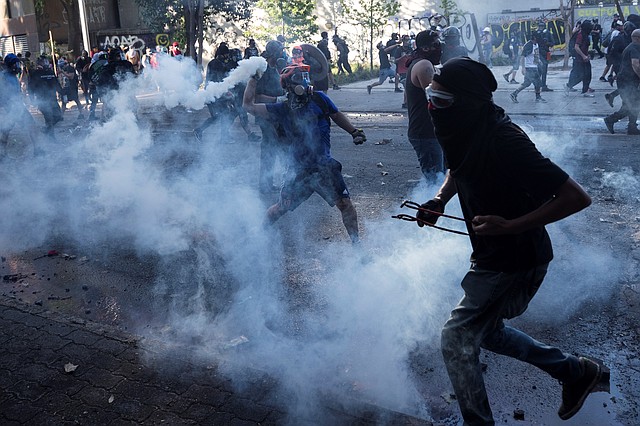 PROTESTAS. Miles de manifestantes se enfrentaron a agentes de seguridad en Plaza Italia, rebautizada popularmente como "Plaza Dignidad", en Santiago. | Foto: Efe/Alberto Valdés.