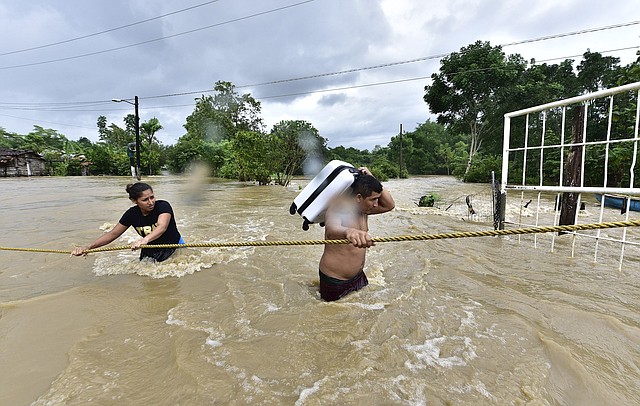 INUNDACIONES. Dos personas cruzando una zona inundada por el desborde de los ríos, el viernes 6 de noviembre, en la sierra de Tabasco (México). | Foto: Efe/Jaime Avalos.