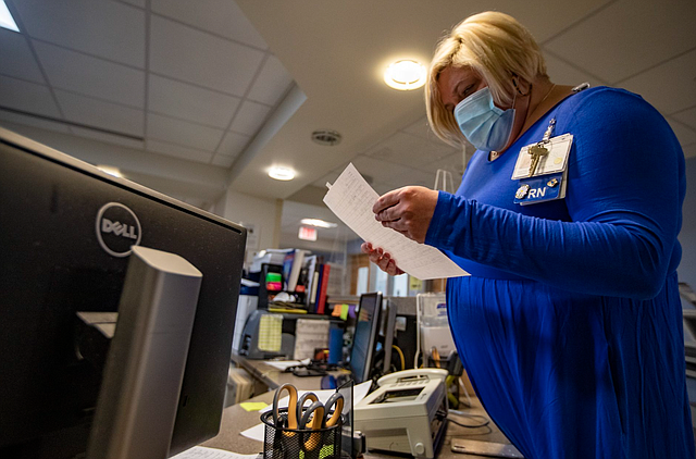 La directora de Enfermería, Kate Baudin, examina una lista de pacientes que se alojan en la unidad especial de enfermedades contagiosas de BMC.